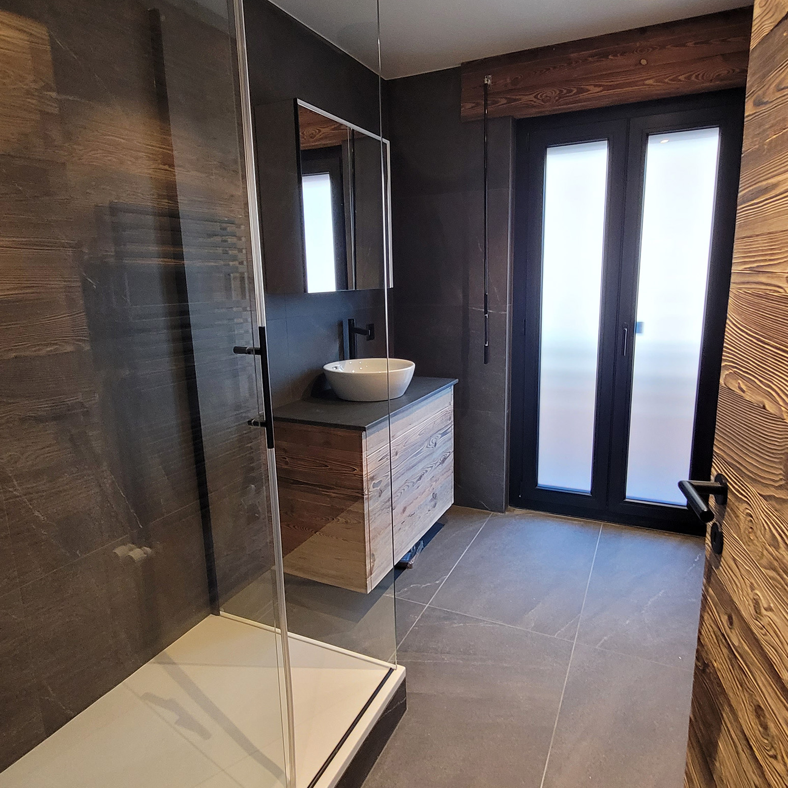 une salle de douche moderne remplace une ancienne cuisine exigüe dans ce 4 pièces et demi transformé à Crans-Montana.transformation Crans-Montana